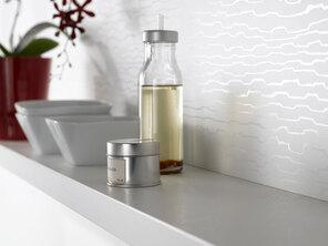 Detailaufnahme eines schmalen weißen Küchenregals mit Dekoration