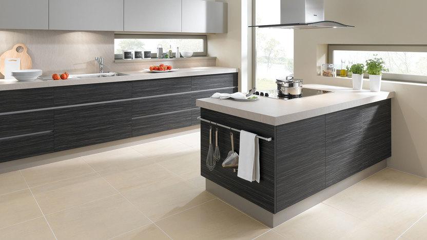 Impression einer Küchengestaltung mit Kochinsel mit Edelstahlabzug und dunklen Fronten