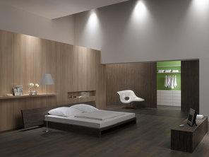 Schlafzimmerimpression von Bett, Nachtisch und Sideboard mit Holzverkleidung an Wand und indirektert Beleuchtung