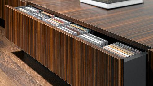 Detailaufnahme eines lackierten Sideboards mit offener Schublade für CD-Aufbewahrung